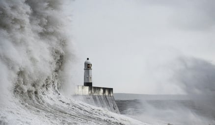 wave crashing on lighthouse