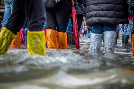 People wearing plastic boot covers wading through water
